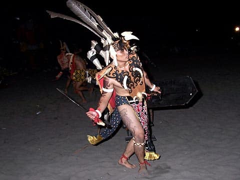 A dancer in feathered Iban headdress and beadwork performing the ngajat