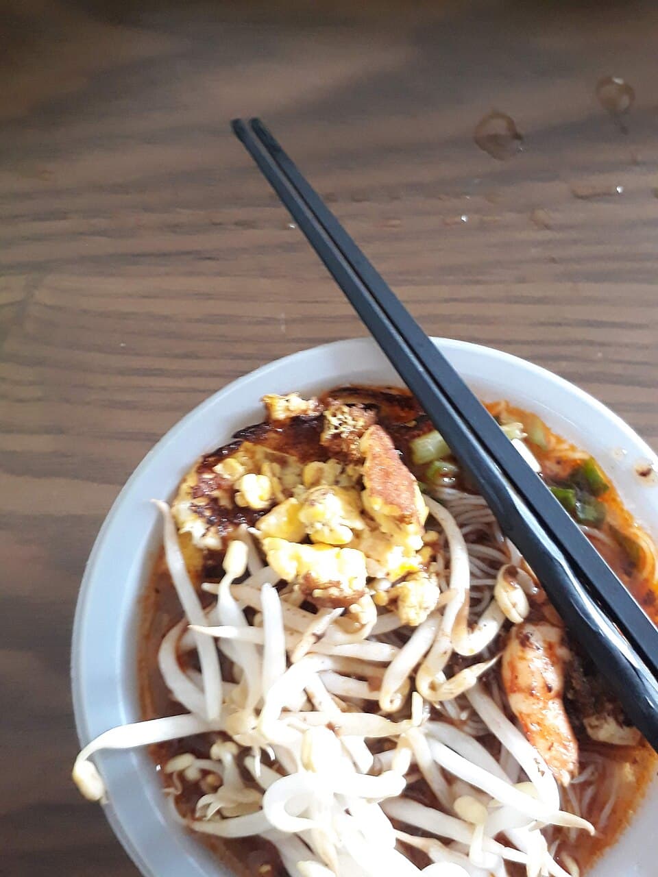 A bowl of Sarawak laksa with prawns, shredded chicken and strips of omelette