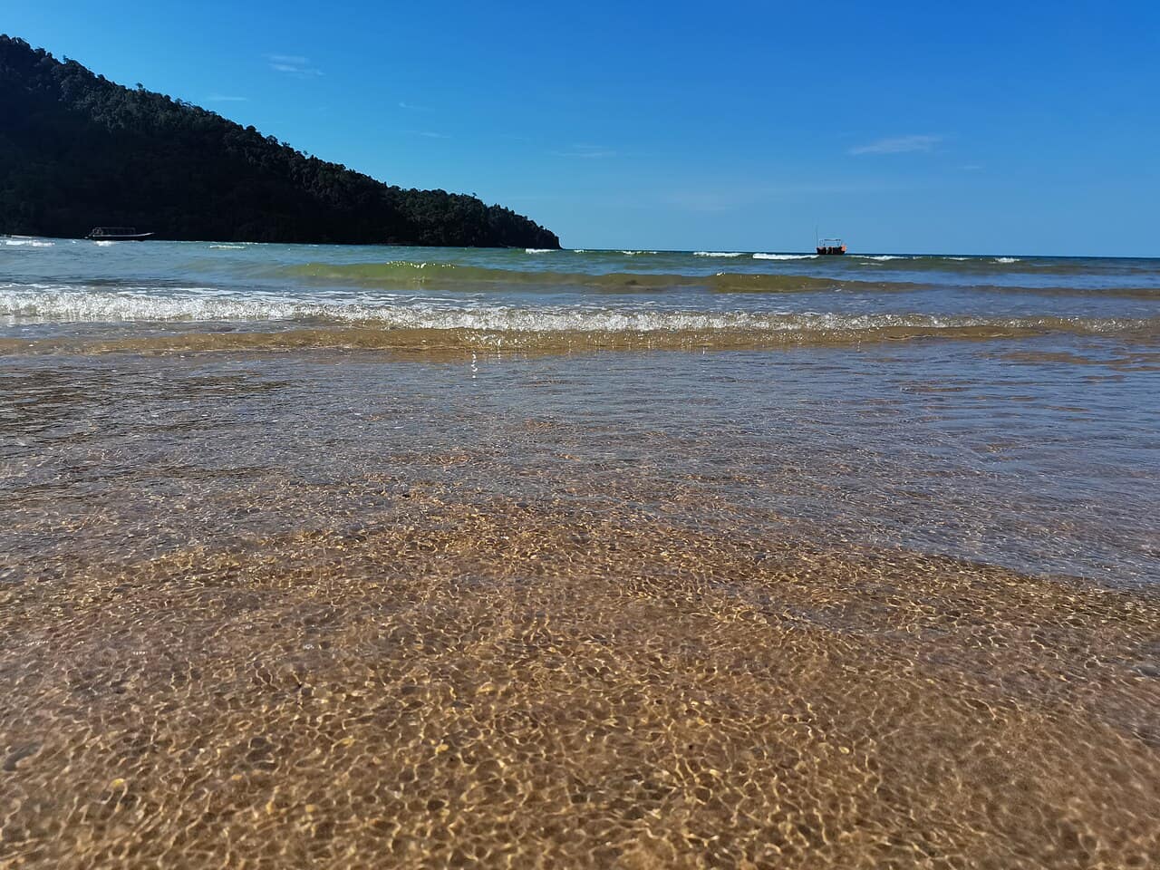 Waves rolling into Telok Melano from the west