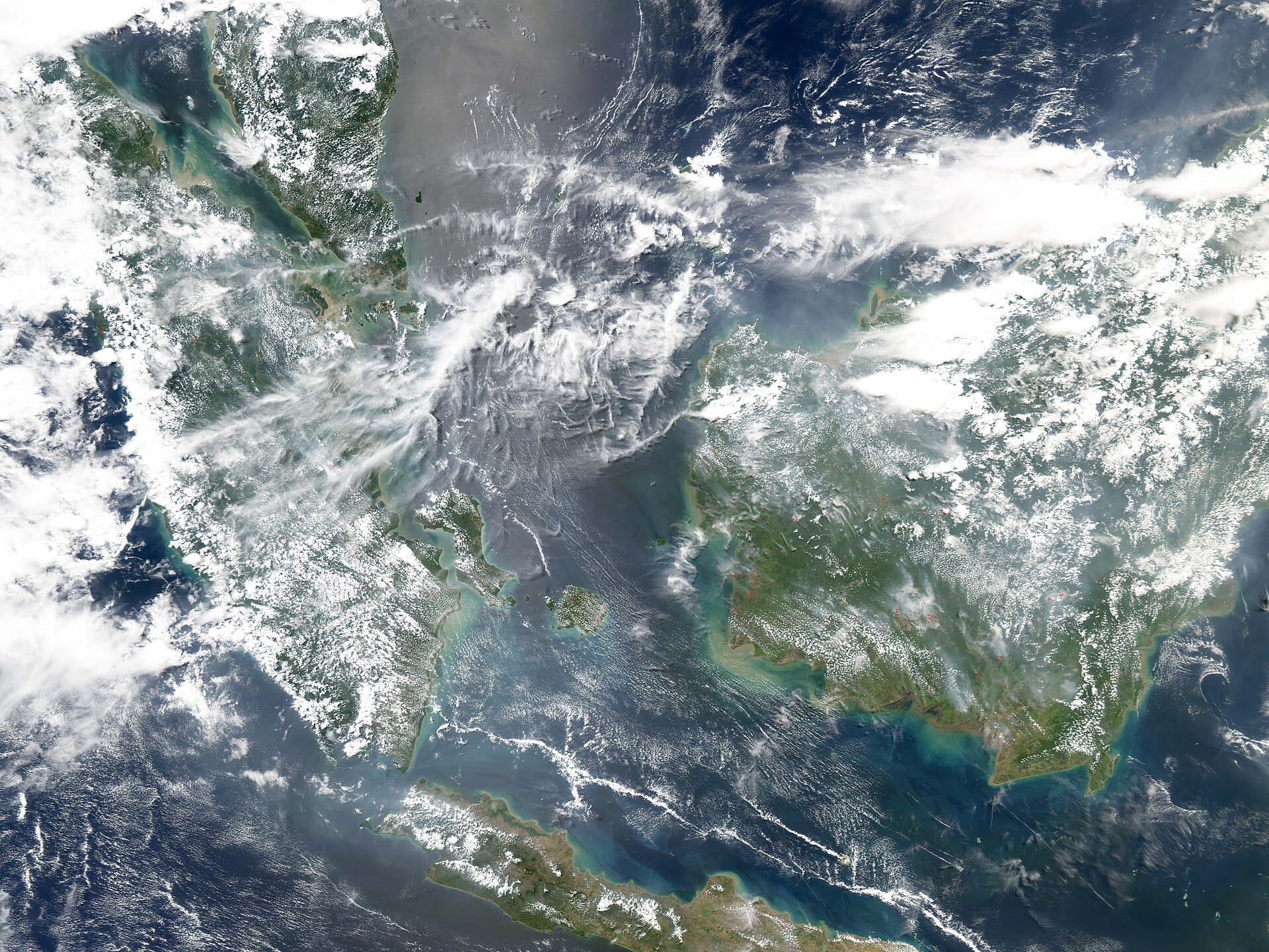 On August 22, 2004, clouds and smoke swirled over the islands that sit between Australia and Asia, at the crossroads of the Indian Ocean to the west and the Pacific Ocean to the east. Large islands pictured here are Borneo (right), Java (bottom), and Sumatra (left) At top left is the southern tip of