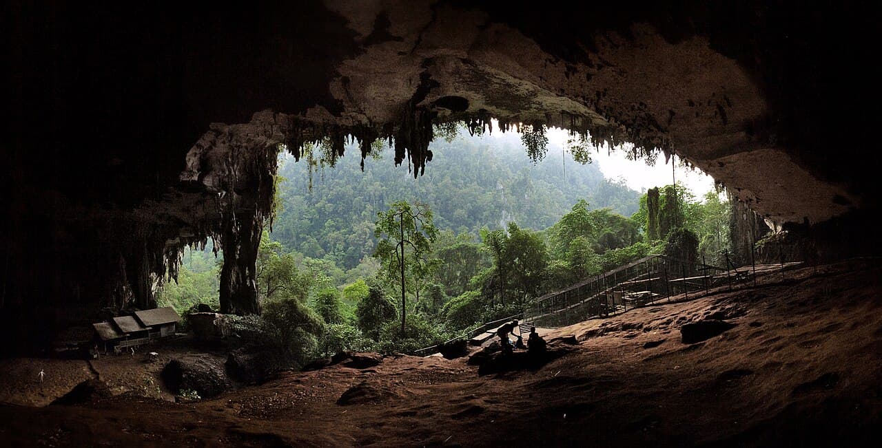 The vast main entrance of the Niah Caves lit gold at sunset