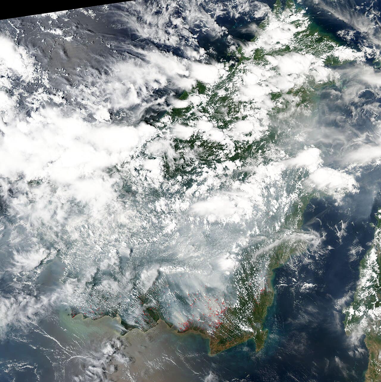 Satellite image showing red fire-detection markers across southern Borneo and a pall of smoke drifting north over the Malaysian part of the island
