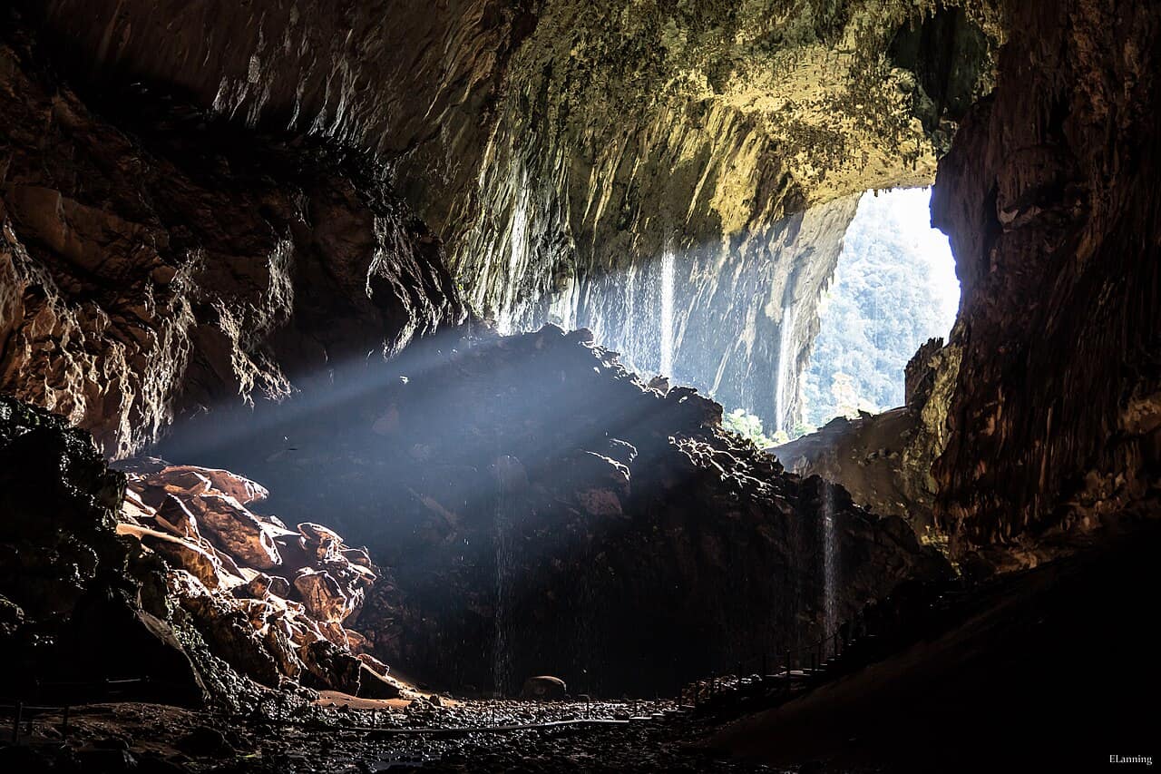 A lit boardwalk threading through a cave passage at Gunung Mulu