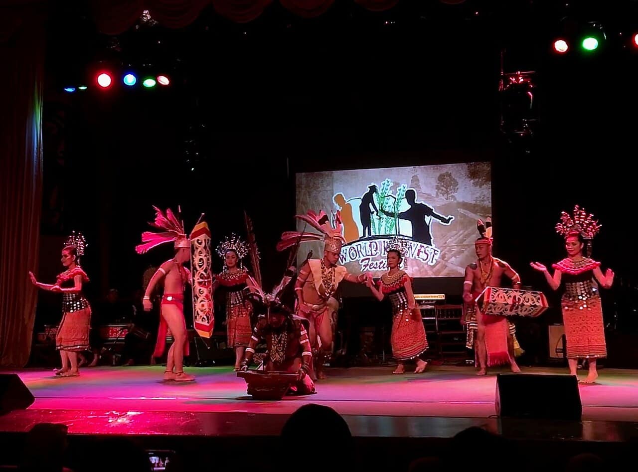 Dancers performing the ngajat in full ceremonial dress on a longhouse floor